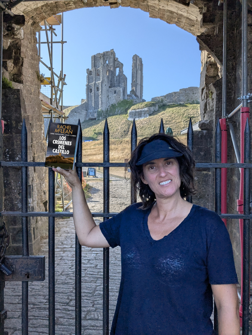 María frente al Castillo de Corfe sosteniendo «Los crímenes del castillo»